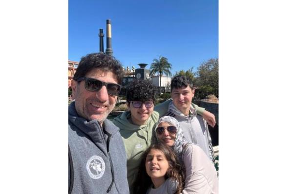 Dr. Ammar Ghanem, an ICU specialist from Detroit volunteering with the Syrian American Medical Society at one of Gaza's last functio<em></em>ning hospitals, left, poses with his family in Orlando, Fla., late Feb. 2024. A group of 35 foreign doctors on a volunteer mission to help at the hospital, including 22 Americans, have been trapped in Gaza by Israel's seizure of the Rafah crossing into Egypt.