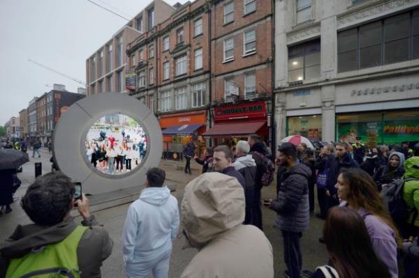 People view the live stream portal between Dublin and New York, in Dublin, Ireland, on Mo<em></em>nday May 13, 2024. (Niall Carson/PA via AP)