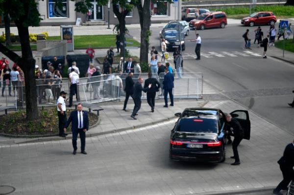 Bodyguards take Slovak Prime Minister Robert Fico in a car from the scene after he was shot and injured following the cabinet's away-from-home session in the town of Handlova, Slovakia, Wednesday, May 15, 2024. Fico is in life-threatening co<em></em>ndition after being wounded in a shooting Wednesday afternoon, according to his Facebook profile. (Radovan Stoklasa/TASR via AP)