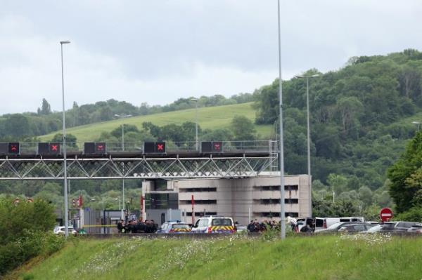 Police officers gather at the site of a ramming attack which took place late morning at a road toll in Incarville in the Eure region of northern France, on May 14, 2024. Two French prison officers were killed and two others wounded on May 14 in an attack on a prison van transporting an inmate who escaped, a police source told AFP. (Photo by ALAIN JOCARD / AFP) (Photo by ALAIN JOCARD/AFP via Getty Images)