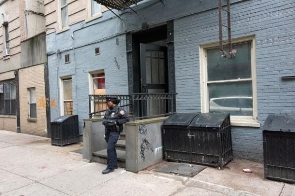 A police officer stands guard outside 304 West 147th Street in Manhattan, New York City after a stabbing on Sunday, May 12, 2024. (Gardiner Anderson for New York Daily News)