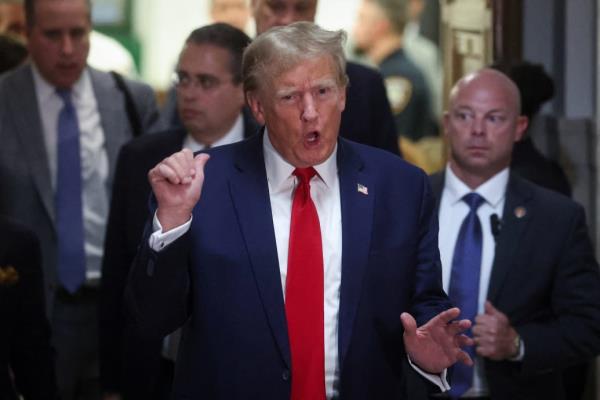 Former President Do<em></em>nald Trump gestures while leaving the courtroom during a break, as he attends the Trump Organization civil fraud trial