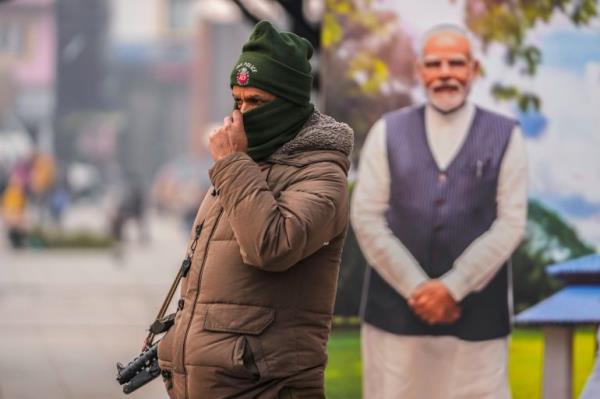 An Indian policeman stands guard near a cutout portrait of Indian Prime Minister Narendra Modi displayed at the main market in Srinagar, Indian co<em></em>ntrolled Kashmir.