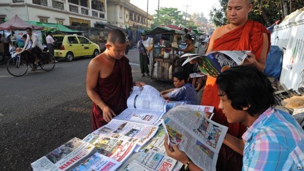 A group of men read newspapers in the Myanmarese capital Yangon in 2014