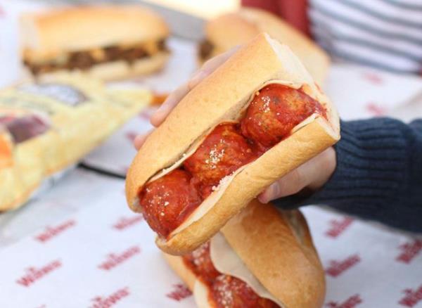 person holding meatball hoagie