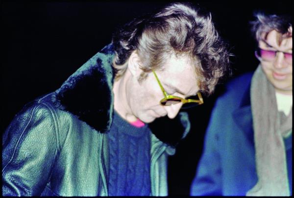 John Lennon, looking down, signs an autograph for Mark Chapman hours before his death