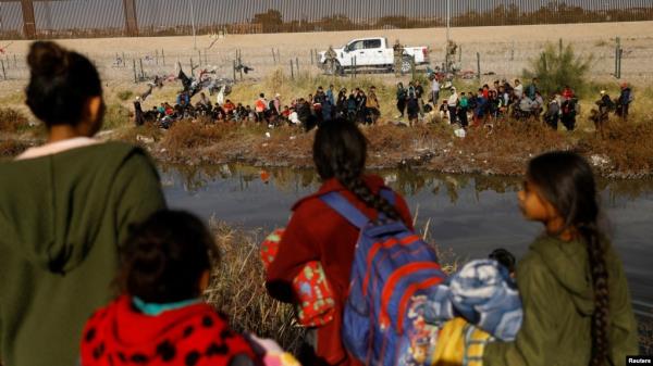 FILE - Migrants seeking asylum in the United States gather on the banks of the Rio Bravo as the Texas Natio<em></em>nal Guard blocks the crossing at the border between the United States and Mexico, as seen from Ciudad Juarez, Mexico, Dec. 5, 2023. 