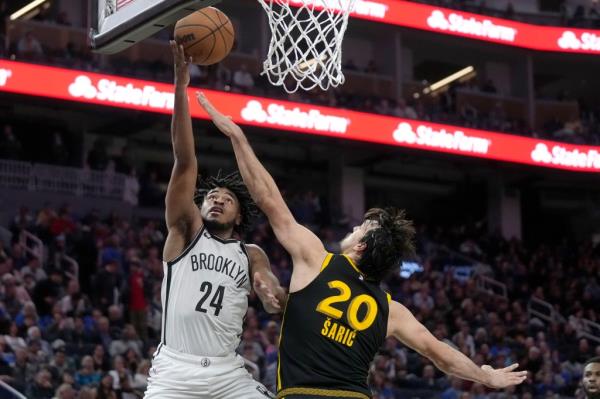 Brooklyn Nets guard Cam Thomas (24) shoots against Golden State Warriors forward Dario Saric.