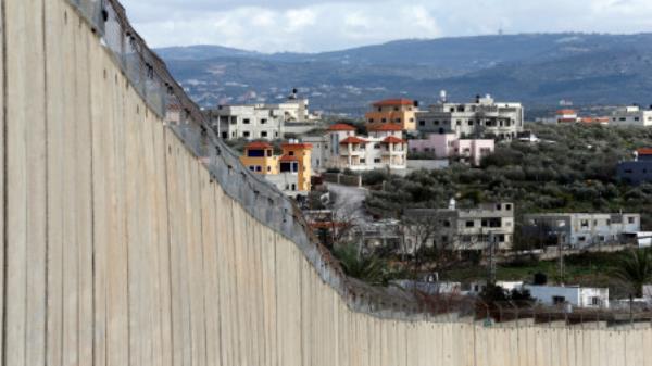 Buildings in the Palestinian village of Nazlat Isa near Tulkarm in the Israeli-occupied West Bank are seen behind the Israeli barrier and from the Arab-Israeli village of Baqa al-Gharbiyye, Israel February 1, 2020/ Reuters