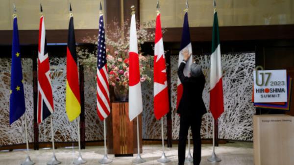 An official adjusts the flags before G7 foreign ministers gather for a family photo during their meetings in Tokyo, Japan, November 8, 2023. REUTERS/Jo<em></em>nathan Ernst/Pool/File Photo