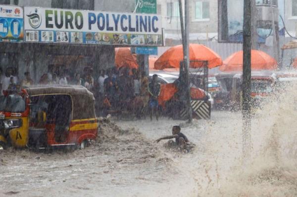 A boy attempts to board a rickshaw taxi to rescue himself from raging flood waters following heavy rains in Mogadishu, Somalia November 9, 2023. 