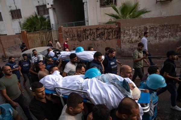 A group of people carry the bodies of two men who were killed in an Israeli airstrike.