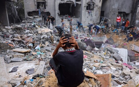 A child reacts as people salvage belo<em></em>ngings amid the rubble of a damaged building following strikes on Rafah in southern Gaza