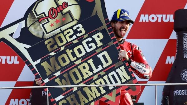 Francesco Bagnaia celebrates on the podium after winning his title-sealing race win