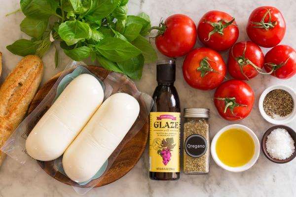 Caprese Christmas tree with fresh mozzarella, tomato slices, fresh basil leaves, balsamic glaze and sea salt flakes.