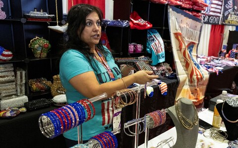 Sany Dash shows off a purse in the shape of a gun at her stall