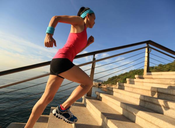 woman doing stair sprints outdoors, co<em></em>ncept of high-intensity cardio exercises for weight loss