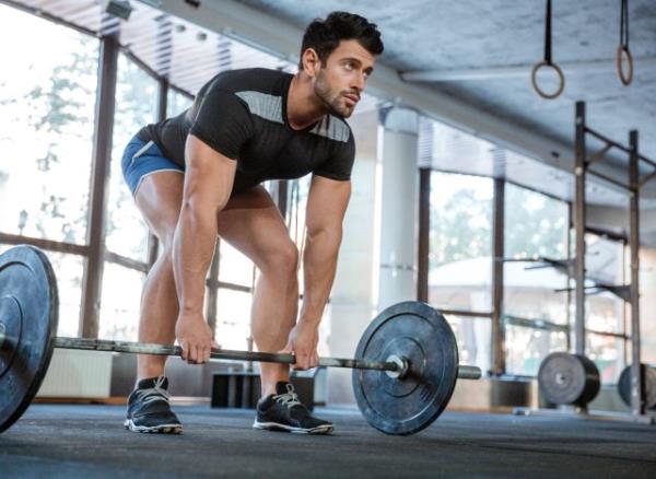 man doing barbell deadlifts exercise, co<em></em>ncept of daily free weight exercises for men to stay fit