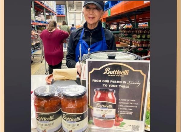 a display of sauce with a server at costco.