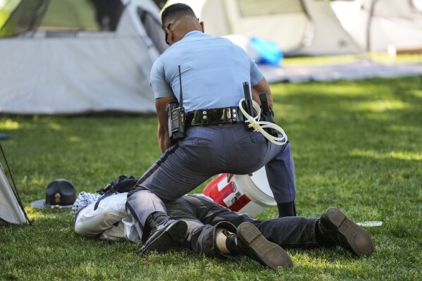 A Georgia State Patrol officer detains a protester on the campus of Emory University during a pro-Palestinian demo<em></em>nstration Thursday, April 25, 2024, in Atlanta. (AP Photo/Mike Stewart)