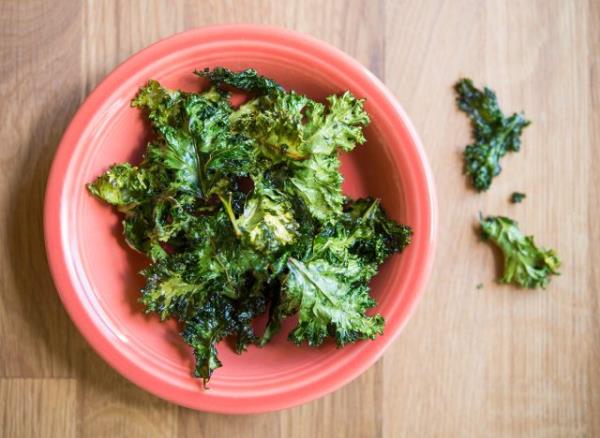 baked kale chips with olive oil and sea salt in an orange bowl