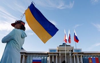 A demo<em></em>nstrator holds a Ukrainian flag outside the Government Palace in Ulaanbaatar to protest against Putin's visit to Mongolia