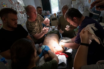 A soldier with shrapnel penetration to his chest is treated in preoperation room 2 before going on via ambulance to a hospital