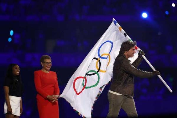 US' actor Tom Cruise leaves with the Olympic flag in front of Los Angeles' Mayor Karen Bass during the closing ceremony of the Paris 2024 Olympic Games at the Stade de France, in Saint-Denis, in the outskirts of Paris, on August 11, 2024. (Photo by Franck FIFE / AFP) (Photo by FRANCK FIFE/AFP via Getty Images)