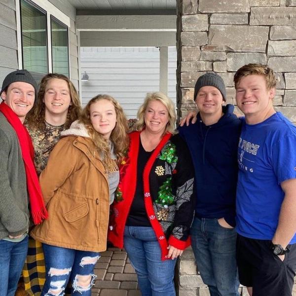 Janelle Brown with her children and another person posing for a photo.