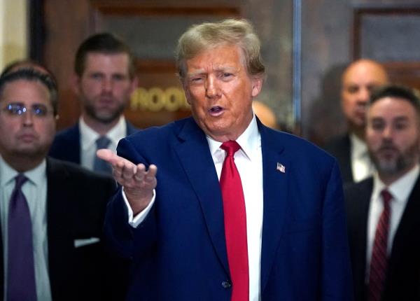 Former US President Do<em></em>nald Trump in a suit and tie, speaking to press outside a court building in New York City on January 11, 2024.