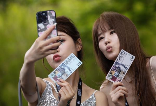 Excited Swifties taking selfies with their co<em></em>ncert tickets before entering Taylor Swift's co<em></em>ncert at Singapore's Natio<em></em>nal Stadium