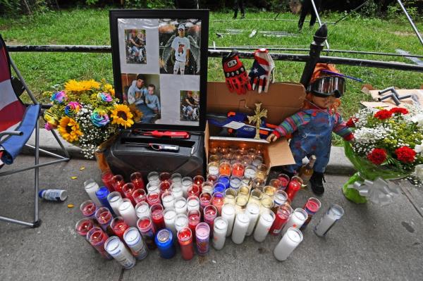 Friends and family gather around a growing memorial for Eric Duprey.