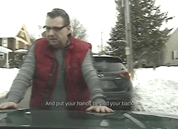 Gregory Bombard is seen with his hands on top of the vehicle after State trooper Jay Riggen mistakenly thought that he flipped him off when he passed him driving through St. Albans, Vermont. 