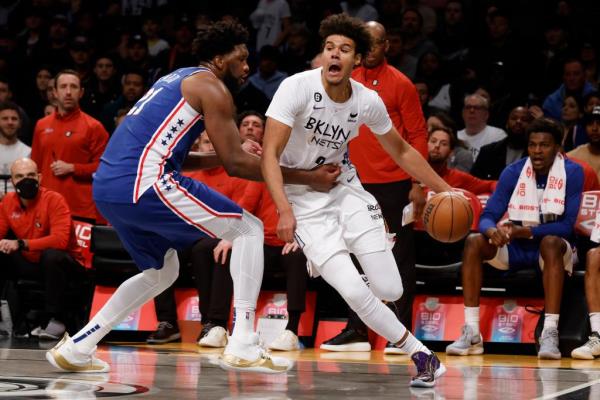 Brooklyn Nets forward Cam Johnson takes a shot while falling back toward Charlotte Hornets forward Kelly Oubre Jr.