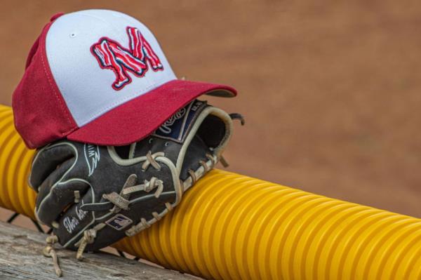 A ba<em></em>seball cap with a M logo made of illustrated bacon sits atop a ba<em></em>seball glove