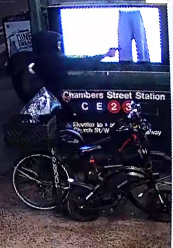 The shooter is seen opening fire from the outside into the 7-Eleven. The World Trade Center PATH train is seen in the background.