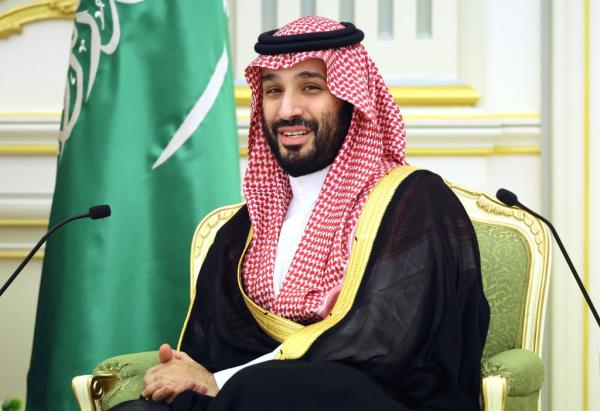 Mohammed bin Salman in dish dasha in a green and gold chair