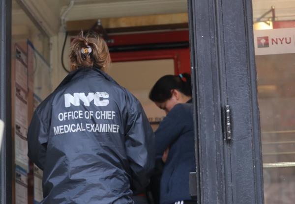 An official with the city's medical examiner's office entering an NYU building. 