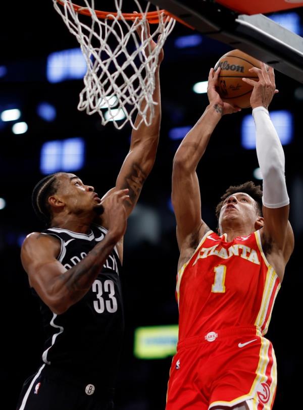 Jalen Johnson #1 of the Atlanta Hawks goes to the basket as Nic Claxton defends during the second half.