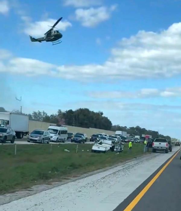 Debris from the crash lies in the median of I-75 as a helicopter flies above in Florida on Friday.