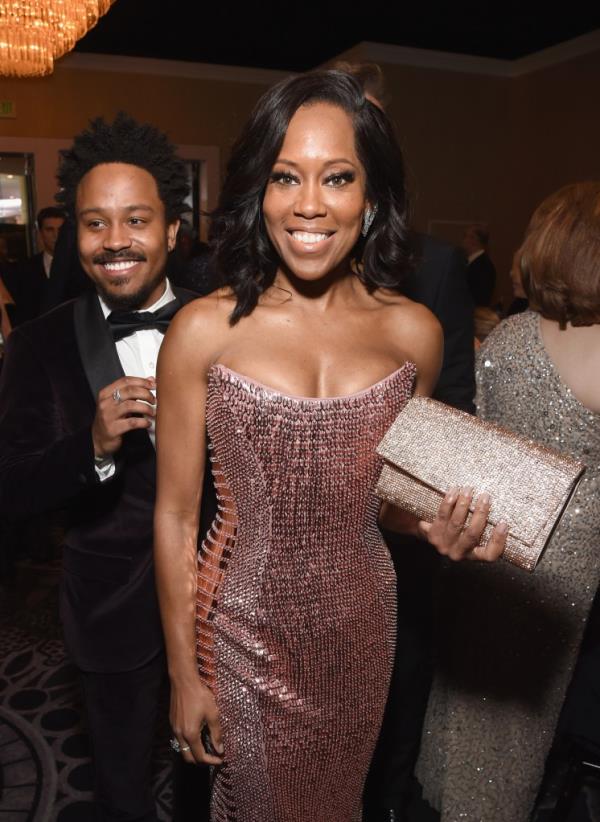 Regina King holding Jimmy Kimmel's hand. 