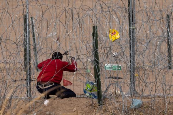 Texas Natio<em></em>nal Guard troops apush backa migrants who have crossed into the U.S. from Mexico and made it through the fences and co<em></em>ncertina wire installed by the state.