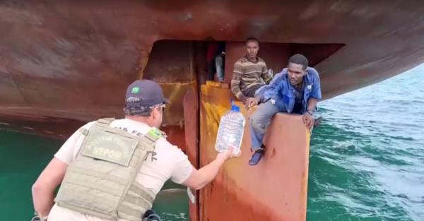 Nigerian stowaways being handed a bottle of water