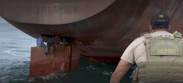 Nigerian stowaways sitting on a cargo ship's rudder