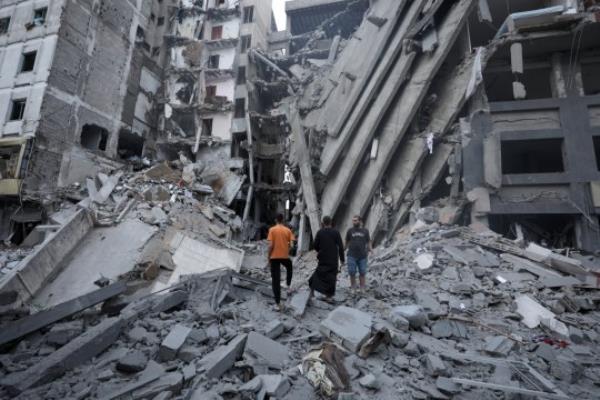 epa10907925 Palsetinians inspect the damage in the surrounding of the destroyed Natio<em></em>nal Bank building following Israeli air strikes, in Gaza City, 08 October 2023. The air strikes in retaliation for the 07 October Hamas rocket attacks on Israel, have killed over 300 people in the Gaza Strip, with almost 2,000 wounded, according to Palestinian official sources. EPA/HAITHAM IMAD