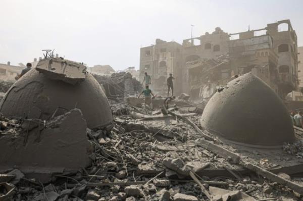 TOPSHOT - Palestinians inspect the damage following an Israeli airstrike on the Sousi mosque in Gaza City on October 9, 2023. Israel co<em></em>ntinued to battle Hamas fighters on October 9 and massed tens of thousands of troops and heavy armour around the Gaza Strip after vowing a massive blow over the Palestinian militants' surprise attack. (Photo by MAHMUD HAMS / AFP) (Photo by MAHMUD HAMS/AFP via Getty Images)