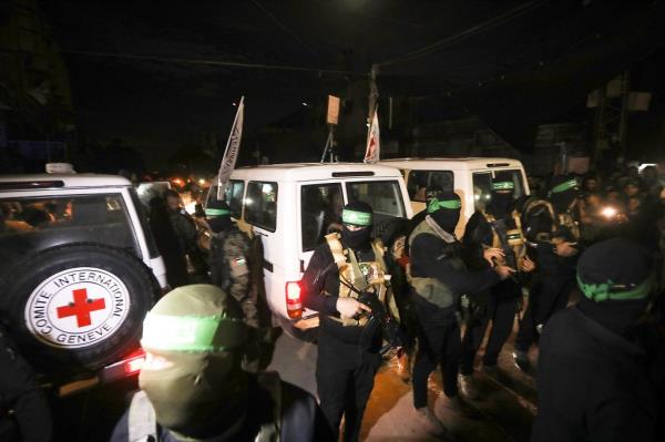 Hamas terrorists accompany newly released hostages before handing them over to the Red Cross in Rafah in the southern Gaza Strip on Nov. 28, 2023.