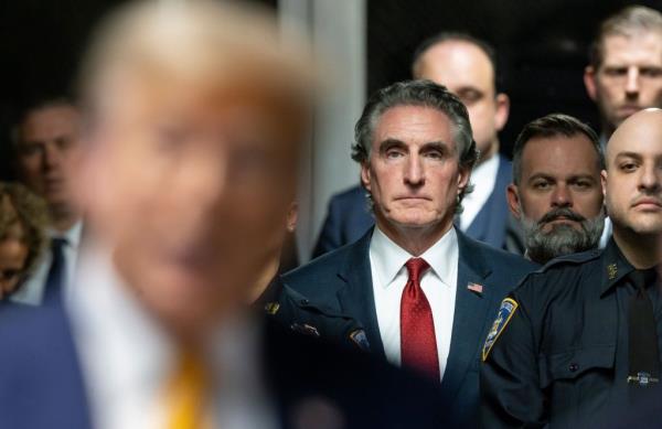 Former US President Do<em></em>nald Trump speaking to reporters outside the courtroom with North Dakota Governor Doug Burgum listening attentively