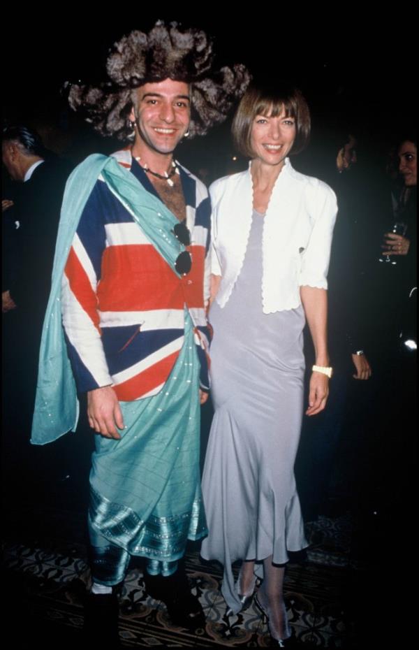 John Galliano and Anna Wintour posing for a picture.