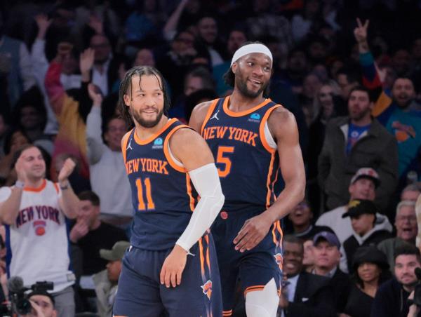 New York Knicks basketball players Jalen Brunson and Precious Achiuwa smiling after a fast break dunk during game against Memphis Grizzlies.